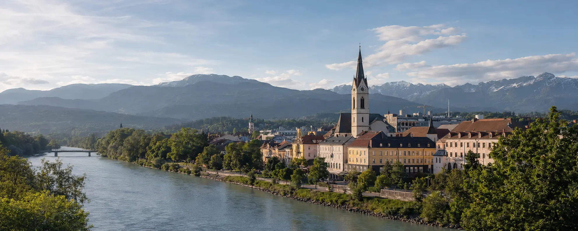 Blick über Villach an der Drau mit Stadtpfarrkirche und Bergen